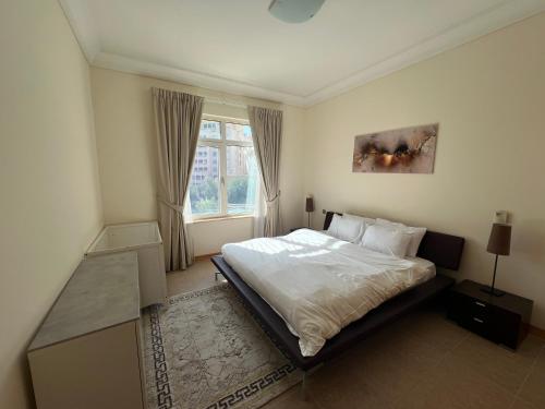 a bedroom with a large bed and a window at Palm Jumeirah - Dubai 3 Bedroom Park Side - With Beach Access in Dubai