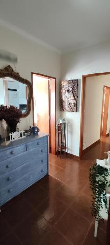 a bathroom with a blue dresser and a mirror at Casa da Avó Isaura - Ericeira in Ericeira