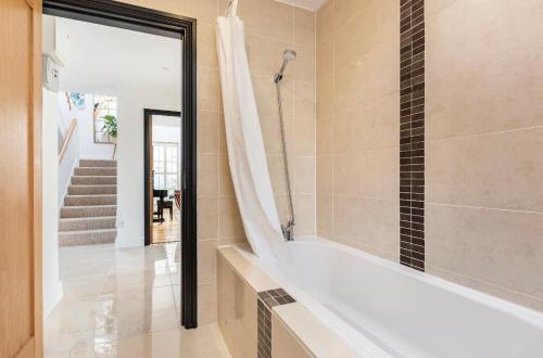 y baño con ducha y bañera. en Private bedroom with bath easy to city center, en Dublín