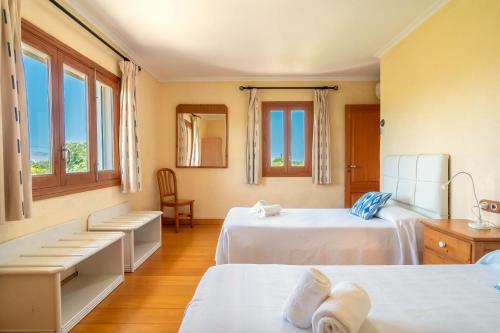 2 Betten in einem Zimmer mit 2 Fenstern in der Unterkunft Villa Can Gosp in Alcúdia