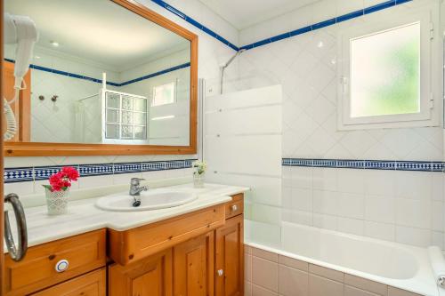 ein Badezimmer mit einem Waschbecken, einer Badewanne und einem Spiegel in der Unterkunft Villa Can Gosp in Alcúdia