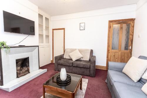 a living room with a couch and a fireplace at April Disc - Long Stay - Contractors in Swindon