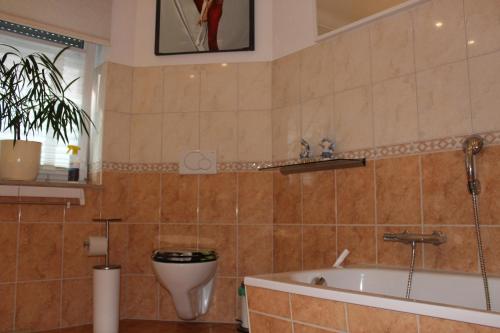 ein Badezimmer mit einer Badewanne, einem WC und einem Waschbecken in der Unterkunft Haus am See in Bernburg
