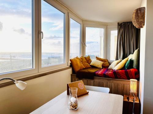 uma sala de estar com um sofá e janelas em The Sun - by Caparica Villas em Costa da Caparica