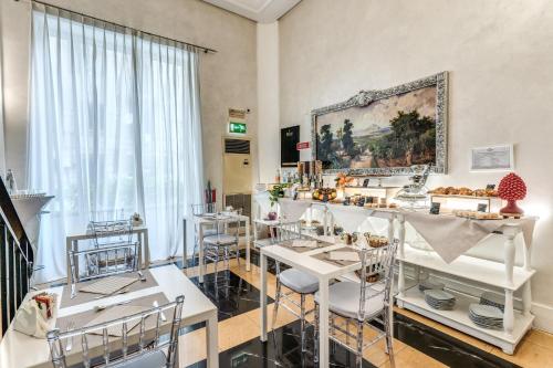 a room with tables and chairs and a painting on the wall at Artemisia Palace Hotel in Palermo