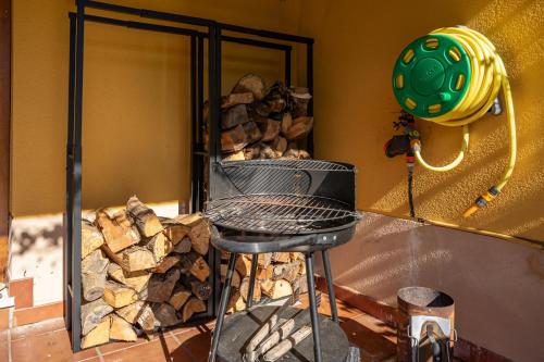 einen Grill in einem Raum mit einem Haufen Feuerholz in der Unterkunft Casa ideal para familia en Ribadesella Africa in Cuerres