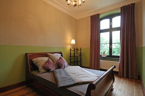 - une chambre avec un lit, une fenêtre et un lustre dans l'établissement Suite Georg Anno 1869 HERRENHAUS VIECHELN, à Behren-Lübchin