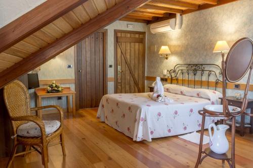 a bedroom with two beds and a table and chairs at Hotel Terra in Padrón