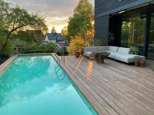 a swimming pool on top of a wooden deck with a couch at Ferienwohnung am Einsteinhaus Caputh in Caputh