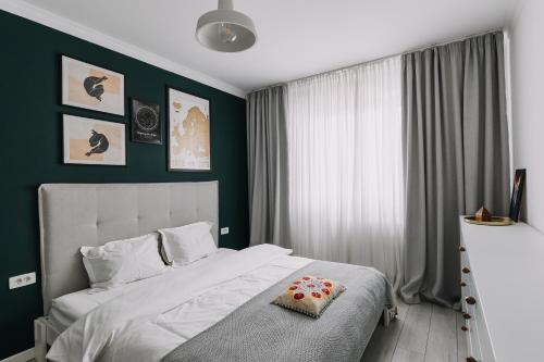 um quarto com uma cama branca e uma parede verde em DreamHome Studio em Brasov