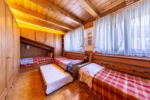 Habitación con 2 camas en una casa de madera en Villa Pais 3 cime View en Auronzo di Cadore