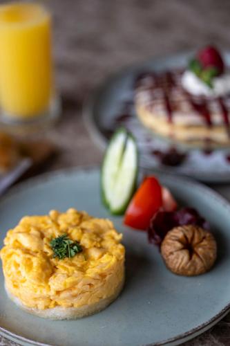 a plate of food with an omelet and fruit at Actor Hotel in Skopje