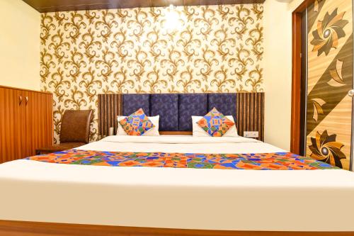 a bedroom with a large bed with a blue wall at FabHotel Spark in Jaipur