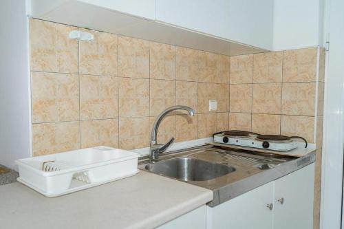 a small kitchen with a sink and a stove at Anna's Studios & Apartments in Laganas