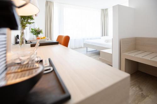a kitchen and living room with a table and a couch at Mercure Chur City West in Chur