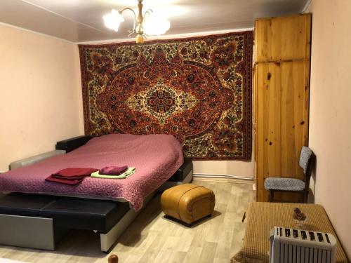 1 dormitorio con 1 cama con alfombra en la pared en Rose garden, en Batovo