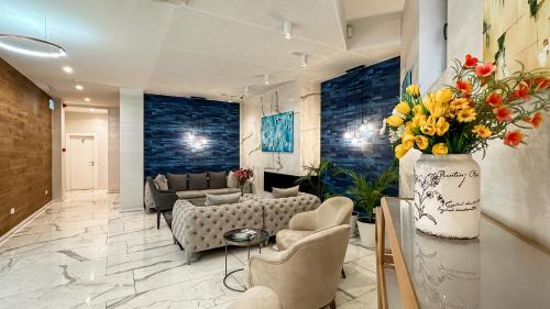 a living room with a couch and chairs and flowers at Silver 39 Corner Hotel in Tbilisi City