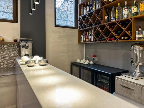 a kitchen with a long counter with bottles on the wall at Silver 39 Corner Hotel in Tbilisi City