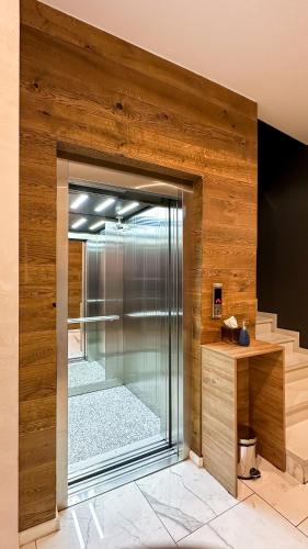 a glass shower in a room with wooden walls at Silver 39 Corner Hotel in Tbilisi City