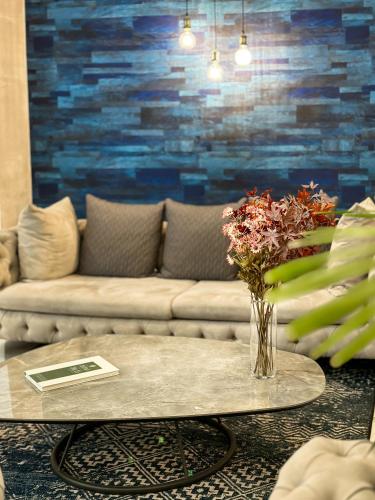 a living room with a couch and a table with flowers at Silver 39 Corner Hotel in Tbilisi City