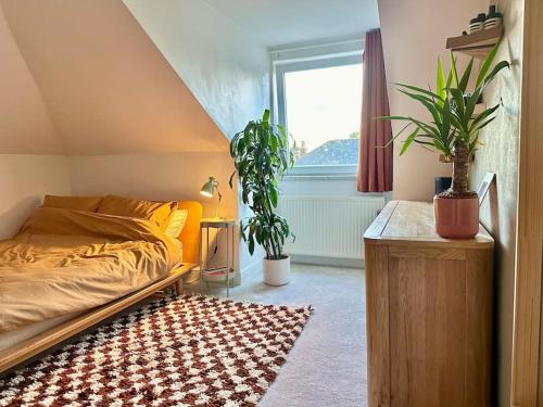 a bedroom with a bed and potted plants and a window at Designer 2 bedroom flat with office in London