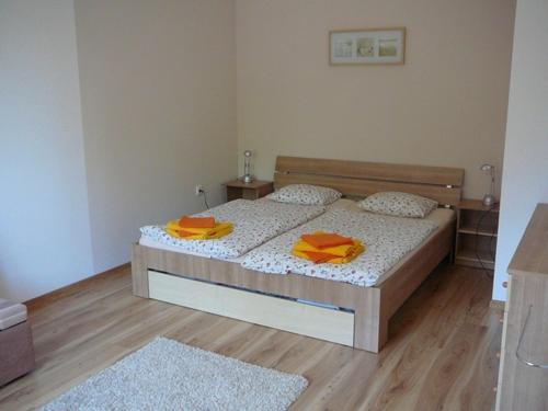 a bedroom with a bed with orange towels on it at Ernesta Club Lipno in Lipno nad Vltavou