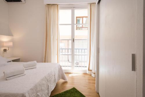 a bedroom with a bed and a large window at Cathedral Suites in Málaga