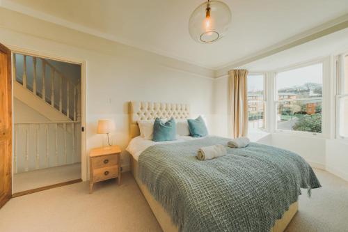 um quarto com uma cama com almofadas azuis e uma janela em St Vincent 3 bedroom property em Bristol