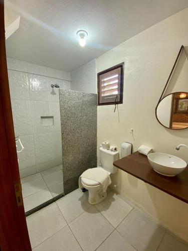 a bathroom with a toilet and a sink and a shower at POUSADA TAIEIRAS in Maragogi