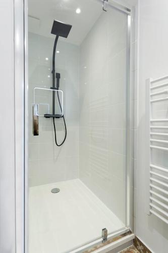 une douche avec une porte vitrée et une lumière noire dans l'établissement Hamac Suites - T3 refurbished - 6 travellers, à Lyon