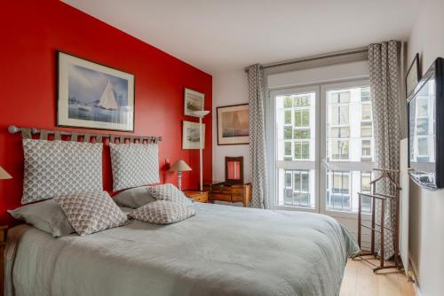 - une chambre avec des murs rouges et un lit avec deux oreillers dans l'établissement Eiffel Tower Elegant Residence, à Paris