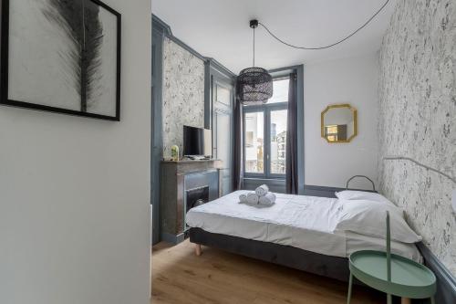 - une chambre avec un lit, deux chaises et une télévision dans l'établissement Hamac Suites - T3 refurbished - 6 travellers, à Lyon
