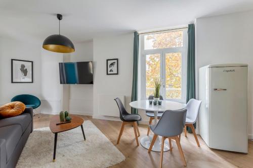 un salon avec une table et un réfrigérateur dans l'établissement Hamac Suites - T3 refurbished - 6 travellers, à Lyon