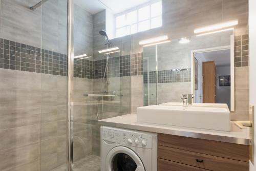 une salle de bain avec un lavabo et une machine à laver dans l'établissement Eiffel Tower Elegant Residence, à Paris