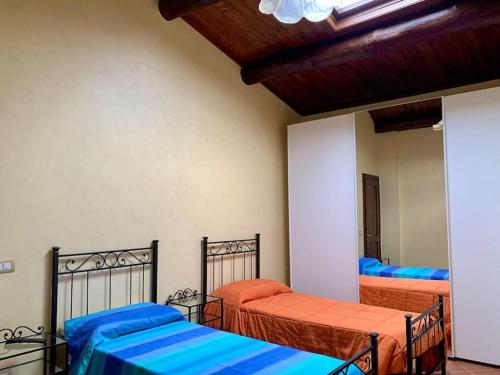 a bedroom with two beds with blue and orange sheets at Il Casale - tra Passato e Modernità 