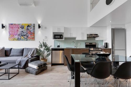 ein Wohnzimmer und eine Küche mit einem Sofa und einem Tisch in der Unterkunft Liv MTL Downtown in Montreal