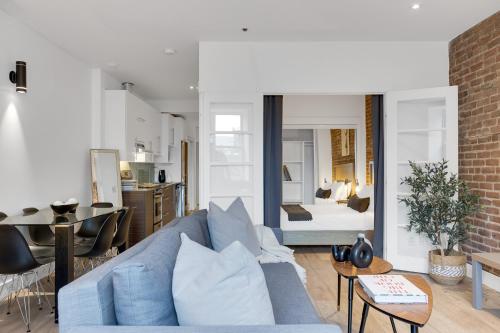 a living room with a blue couch and a bedroom at LiV MTL Downtown in Montréal