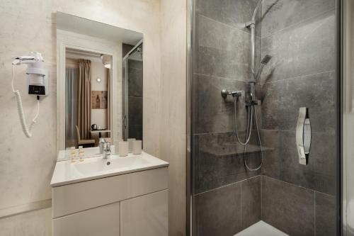 une salle de bain avec douche et lavabo dans l'établissement Hôtel d'Argenson, à Paris