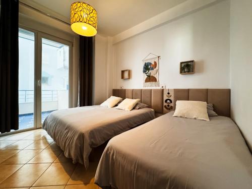 1 dormitorio con 2 camas y ventana grande en Apartment Anna, en Sarandë