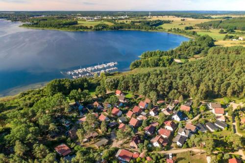Luftblick auf ein Dorf neben einem See in der Unterkunft MöwenKieker mit Terrasse im Ferienpark Silz in Silz