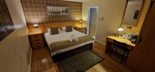 a bedroom with a bed and a desk and a mirror at The Inn At Lathones in St. Andrews