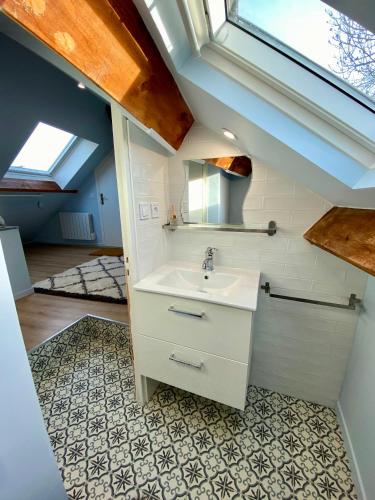 une salle de bain avec un lavabo et un miroir dans l'établissement Les Logis Aux portes de la Vallée de Chevreuse, à Gometz-le-Châtel