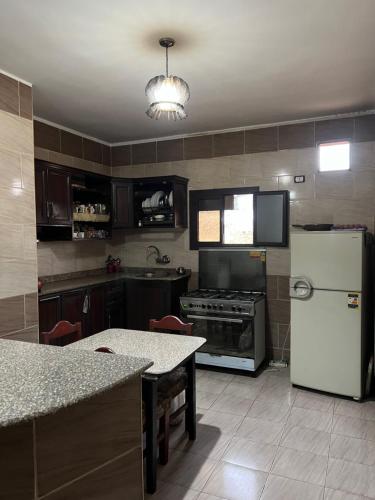 een keuken met een witte koelkast en een fornuis bij Aoda pyramids in Caïro