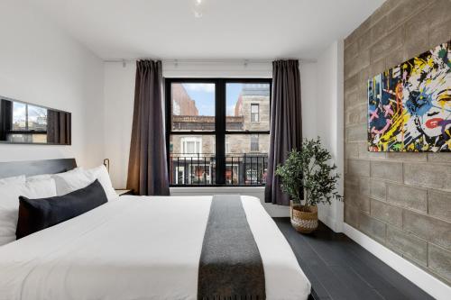 a bedroom with a large bed and a large window at LiV MTL Plato in Montréal
