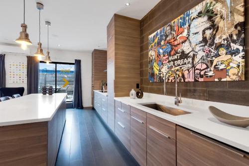 a kitchen with a sink and a large painting on the wall at LiV MTL Plato in Montréal