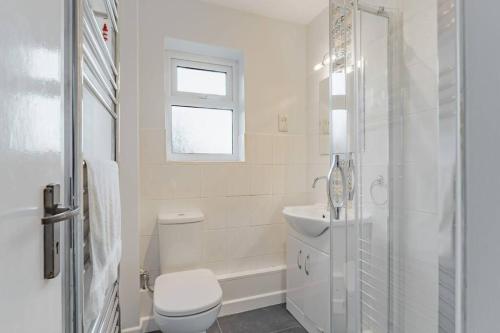 La salle de bains est pourvue de toilettes, d'un lavabo et d'une douche. dans l'établissement Coast Haven - Norfolk Cottage Agency, à Sheringham