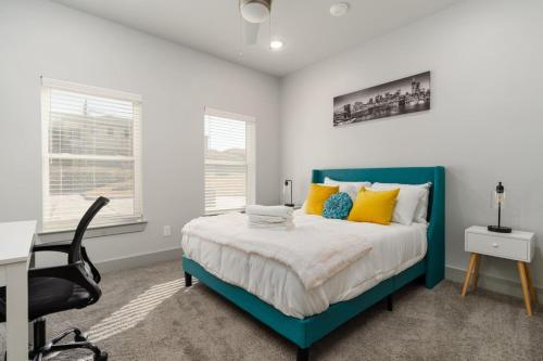 um quarto com uma cama azul e uma secretária em Corporate Housing by MGM em Grand Prairie