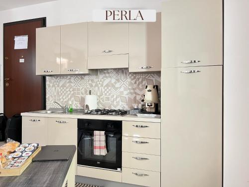 a kitchen with white cabinets and a stove top oven at Residence Lori in Brindisi