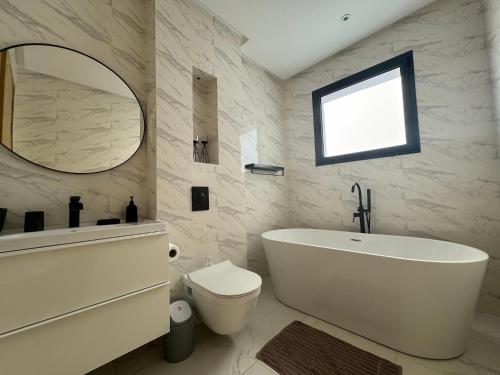 een badkamer met een wastafel, een toilet en een spiegel bij Palais Ouzdi in Marrakesh