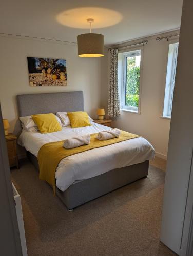 a bedroom with a large bed with yellow pillows at Great Trethew Hotel - Self Catering Lodges - Bar & Restaurant in Liskeard
